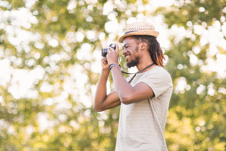 Handsome hipster using vintage camera on a sunny dayの写真素材