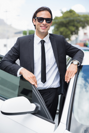 Businessman leaning on the door of his carの写真素材