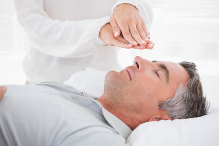 Therapist working with man in medical officeの写真素材