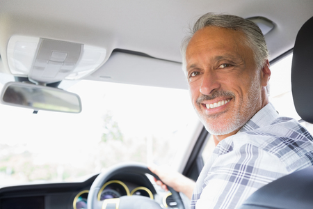 Man smiling while driving in his carの写真素材