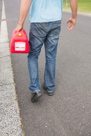 Man bringing petrol canister to a broken down car in the streetの写真素材