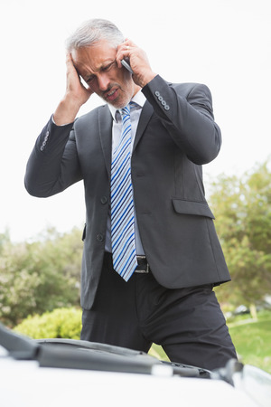 Desperate man calling for assistance after breaking down on the roadの写真素材