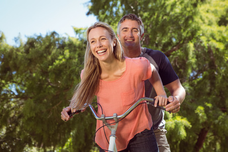 Happy couple on a bike ride on a sunny dayの写真素材