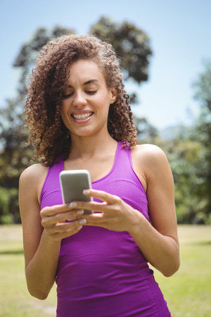Fit woman on the phone in park on a sunny dayの写真素材