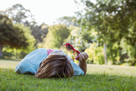 Pretty woman lying down in park on a sunny day