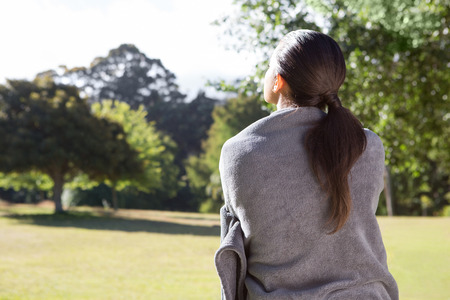 Pretty woman wrapped in blanket on a sunny dayの写真素材