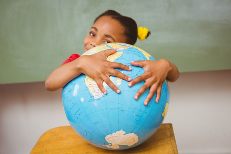Portrait of cute little girl holding globeの写真素材