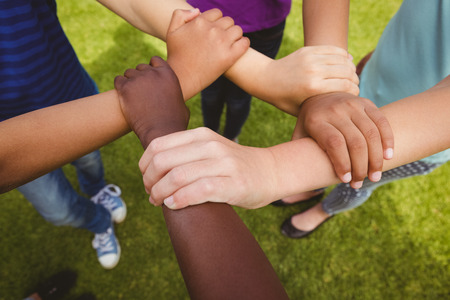 Close up of children holding hands together at the park