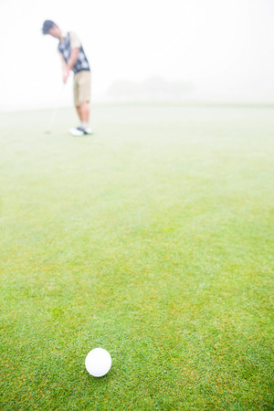 Golfer about to tee off on a sunny day at the golf courseの写真素材
