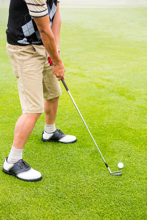 Golfer lining up his shot at the golf courseの写真素材