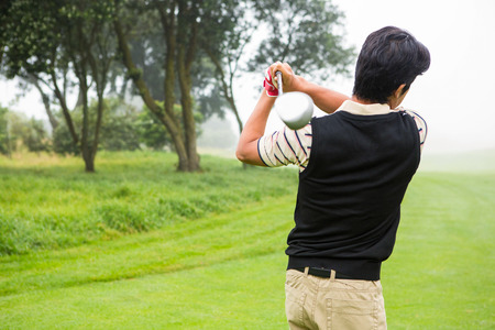 Golfer teeing off at the golf courseの写真素材