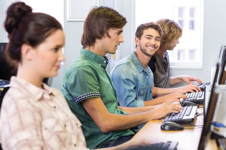Male student smiling at camera in computer classの写真素材
