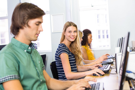 Female student smiling at camera in computer class