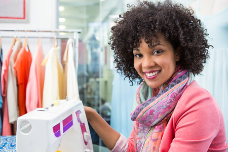 Portrait of attractive female fashion designer using sewing machineの写真素材
