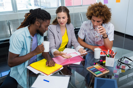 Creative young business people working at office deskの写真素材