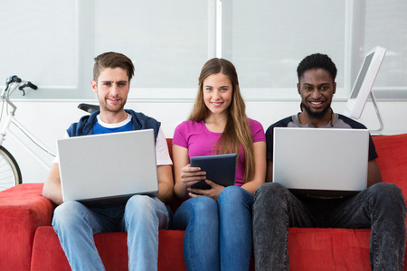 Portrait of creative team using technologies in office