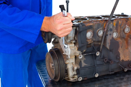 Cropped image of male mechanic repairing car engine on white background