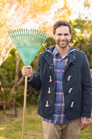 Handsome man smiling in his garden on a sunny dayの写真素材
