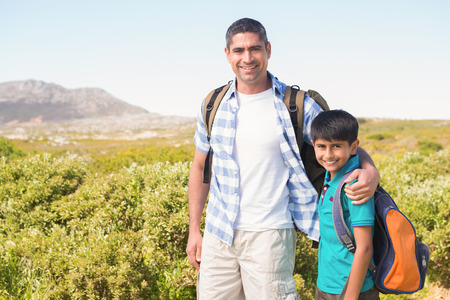 Father and son hiking in the mountains on a sunny dayの写真素材