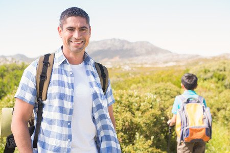 Father and son hiking in the mountains on a sunny dayの写真素材