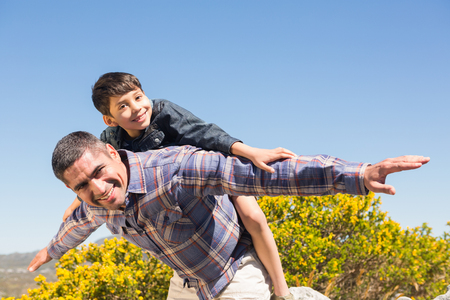 Father and son hiking through mountains on a sunny dayの写真素材