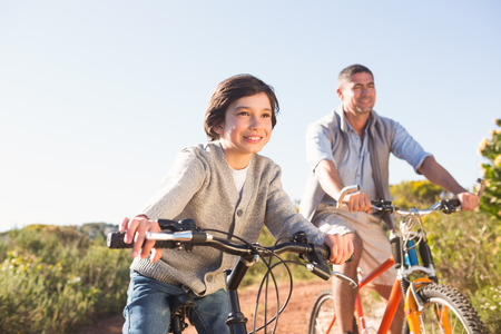 Father and son on a bike ride on a sunny dayの写真素材