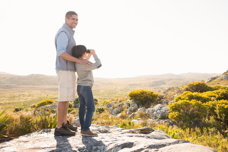 Father and son hiking through mountains on a sunny dayの写真素材