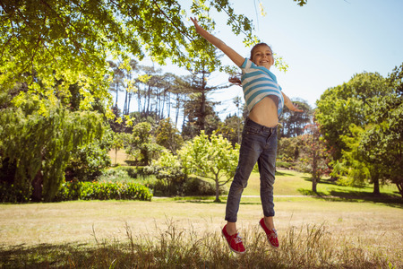Cute little girl jumping up on a sunny dayの写真素材