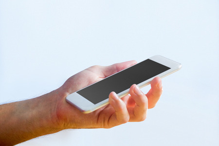 Hand holding a white smartphone in close upの写真素材