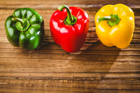 Three peppers on chopping board with copy spaceの写真素材