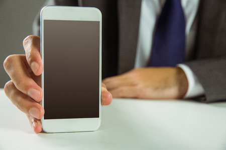 Businessman showing his smart phone in close upの写真素材