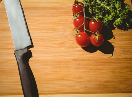 Cherry tomatoes and parsley on chopping board with copy spaceの写真素材