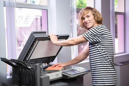 Student photocopying his book in the library at the universityの写真素材