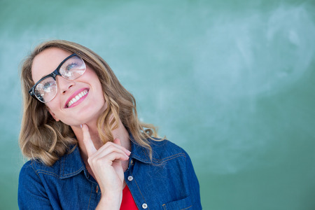 Smiling geeky teacher standing in front of blackboard in classroomの写真素材