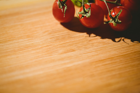 Cherry tomatoes on chopping board with copy spaceの写真素材