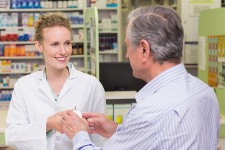 Pharmacist explaining something to a customer in the pharmacyの写真素材