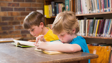 Cute pupils reading in library at elementary schoolの写真素材