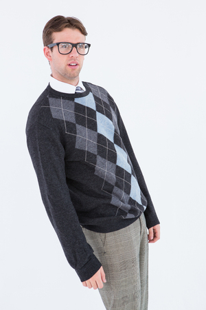 Geeky hipster leaning looking at camera on white backgroundの写真素材