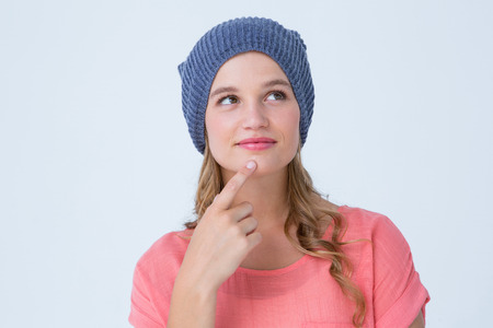 Thoughtful hipster woman with hat on white background