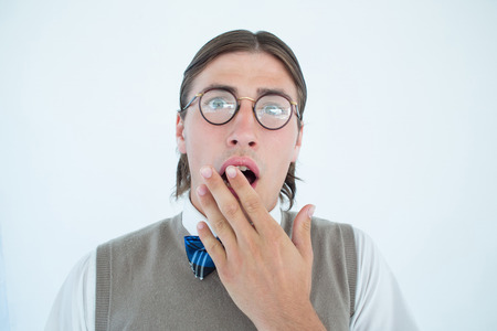Geeky hipster looking surprised at camera on white backgroundの写真素材