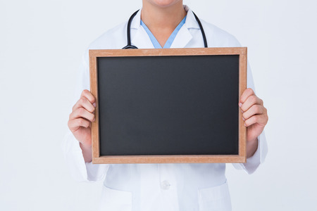 Doctor showing little blackboard on white backgroundの写真素材