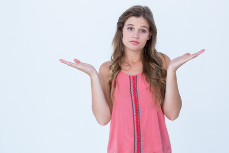 Unsure woman gesturing do not know sign on white backgroundの写真素材