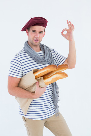 French guy with beret holding baguettes on white backgroundの写真素材