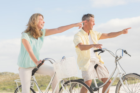 Happy couple on a bike ride at the beachの写真素材