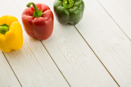 Three peppers on chopping board with copy spaceの写真素材