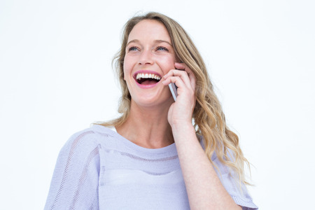 Smiling woman using smartphone on white backgroundの写真素材