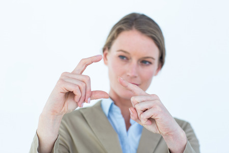 Businesswoman pointing with her finger on white backgroundの写真素材