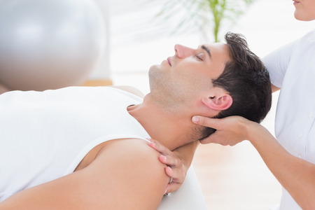 Man receiving neck massage in medical officeの写真素材