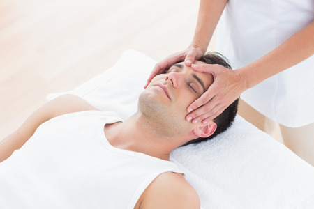 Man receiving head massage in medical officeの写真素材