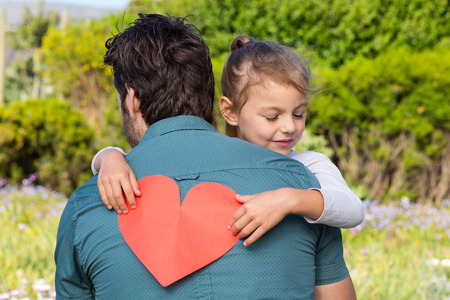 Daughter giving dad a heart card in the countrysideの写真素材